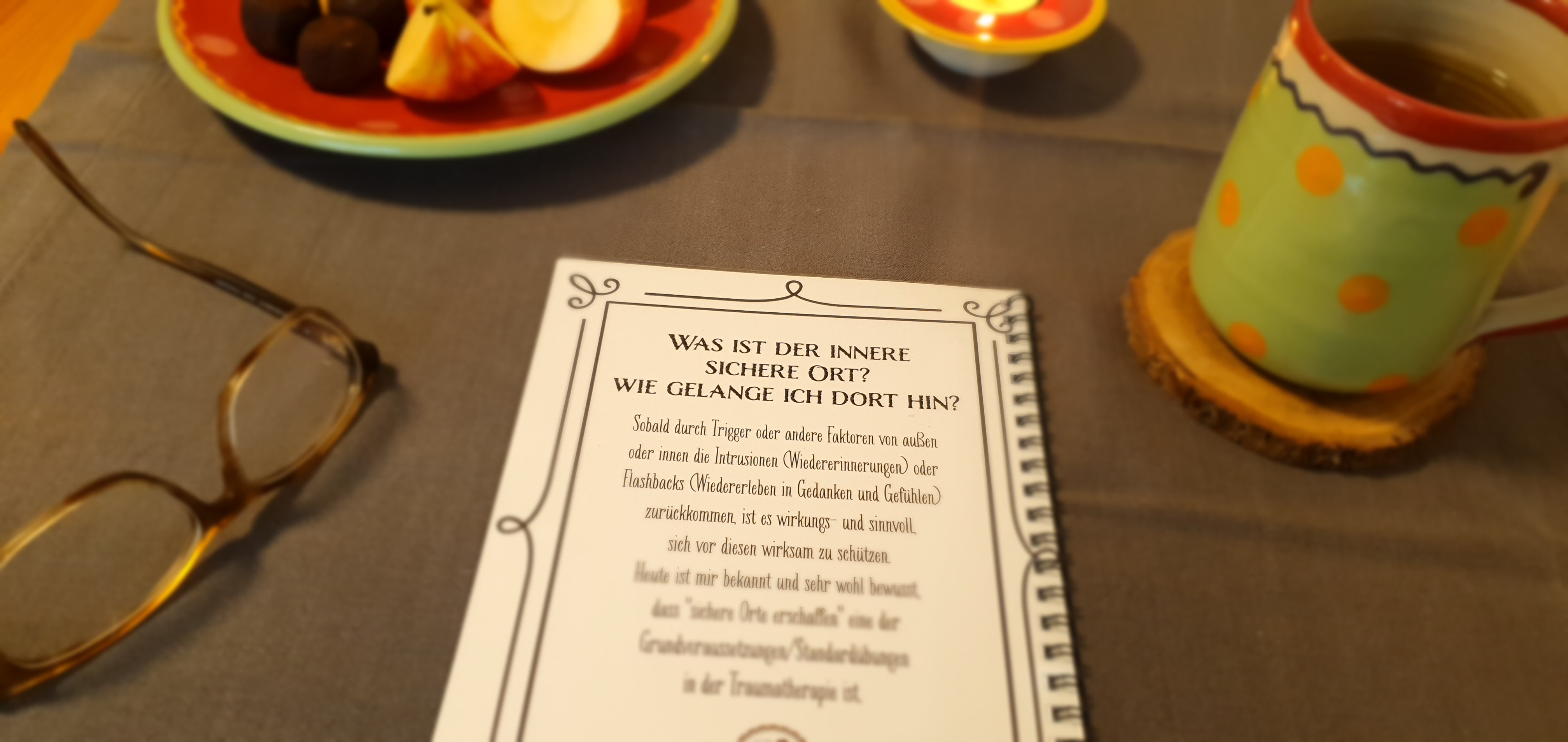 Auf einem Tisch ist das Kursbuch und die sieben verschiedenen Heilsteine